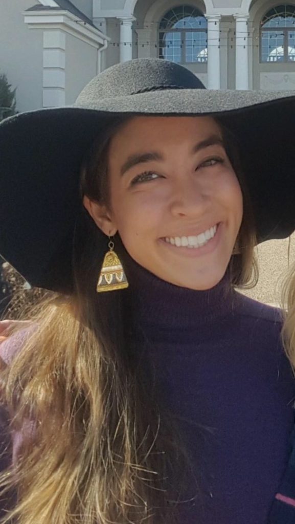 Image of Christi Burrows smiling and wearing a black hat.